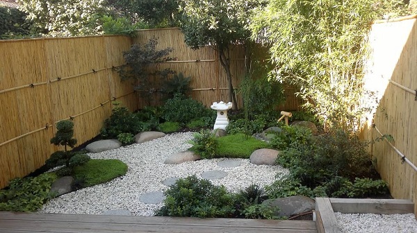 Coin jardin très bien aménagé avec des galets et de la végétation